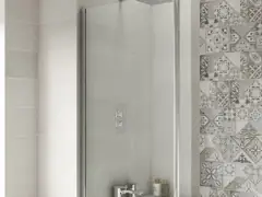 Glass screen panel over a bathtub with tiled walls