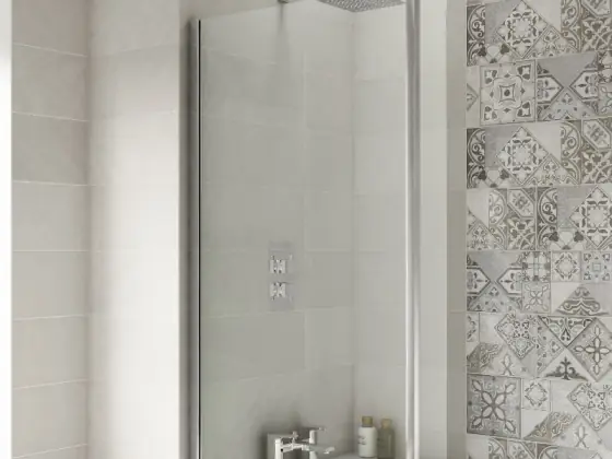 Glass screen panel over a bathtub with tiled walls