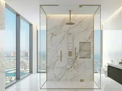Frameless glass shower partition in a modern marble bathroom