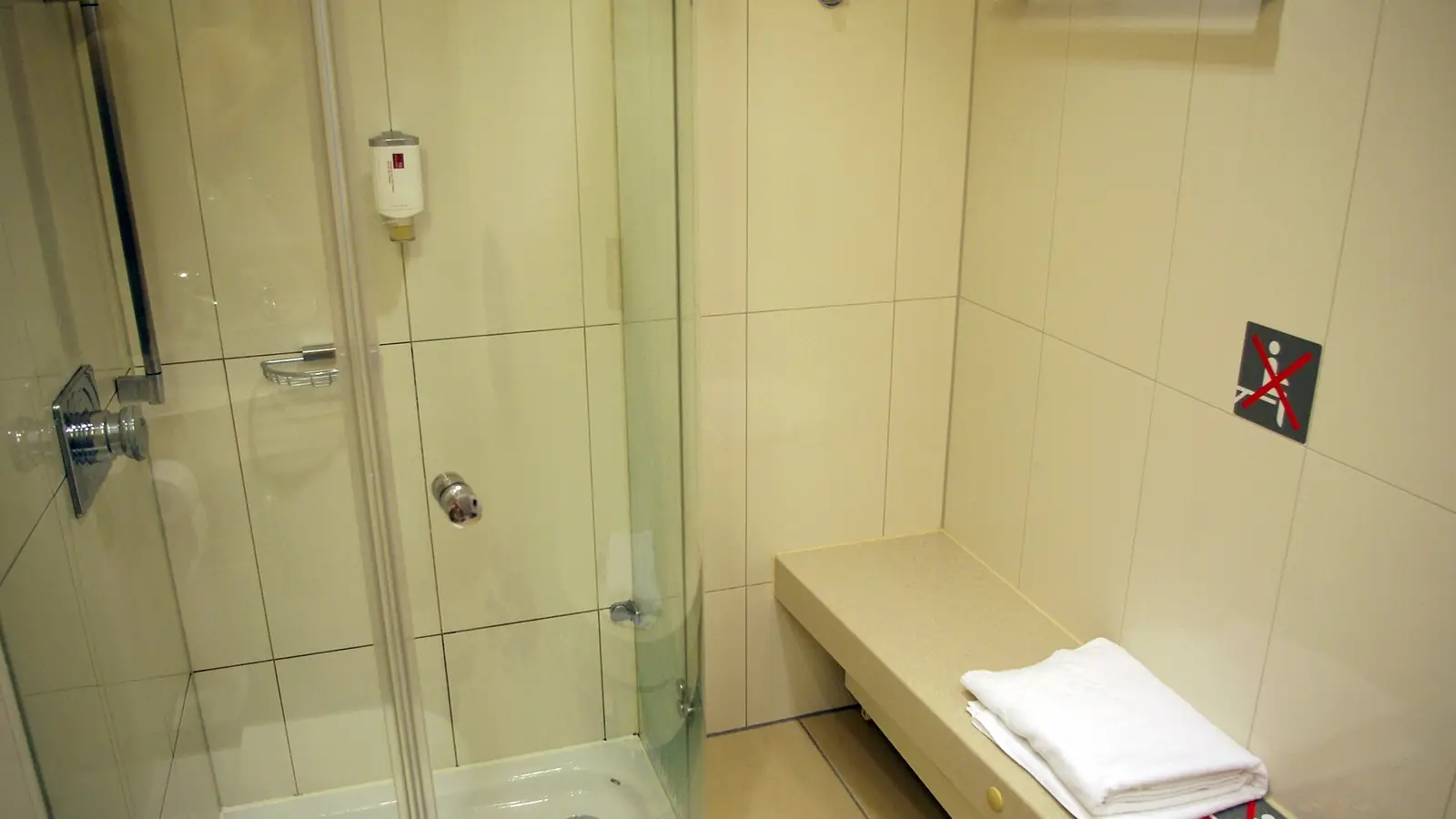 Walk-in shower behind a clear glass panel and door