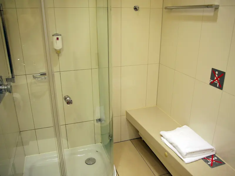 Walk-in shower behind a clear glass panel and door