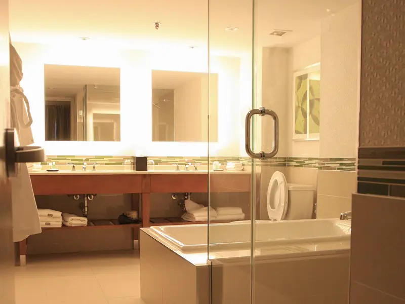 Hotel suite bathroom with a frameless glass shower door and soaking tub