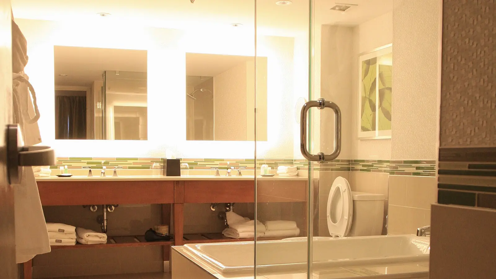 Hotel suite bathroom with a frameless glass shower door and soaking tub