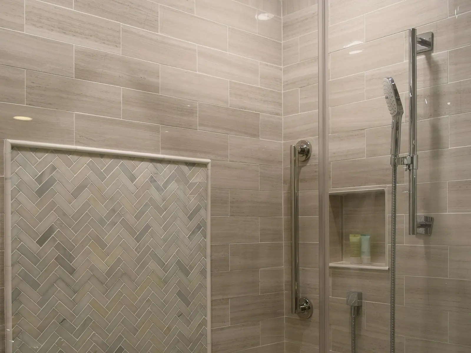 Walk-in shower with frameless glass, rain showerhead and herringbone tile