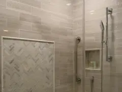 Walk-in shower with frameless glass, rain showerhead and herringbone tile