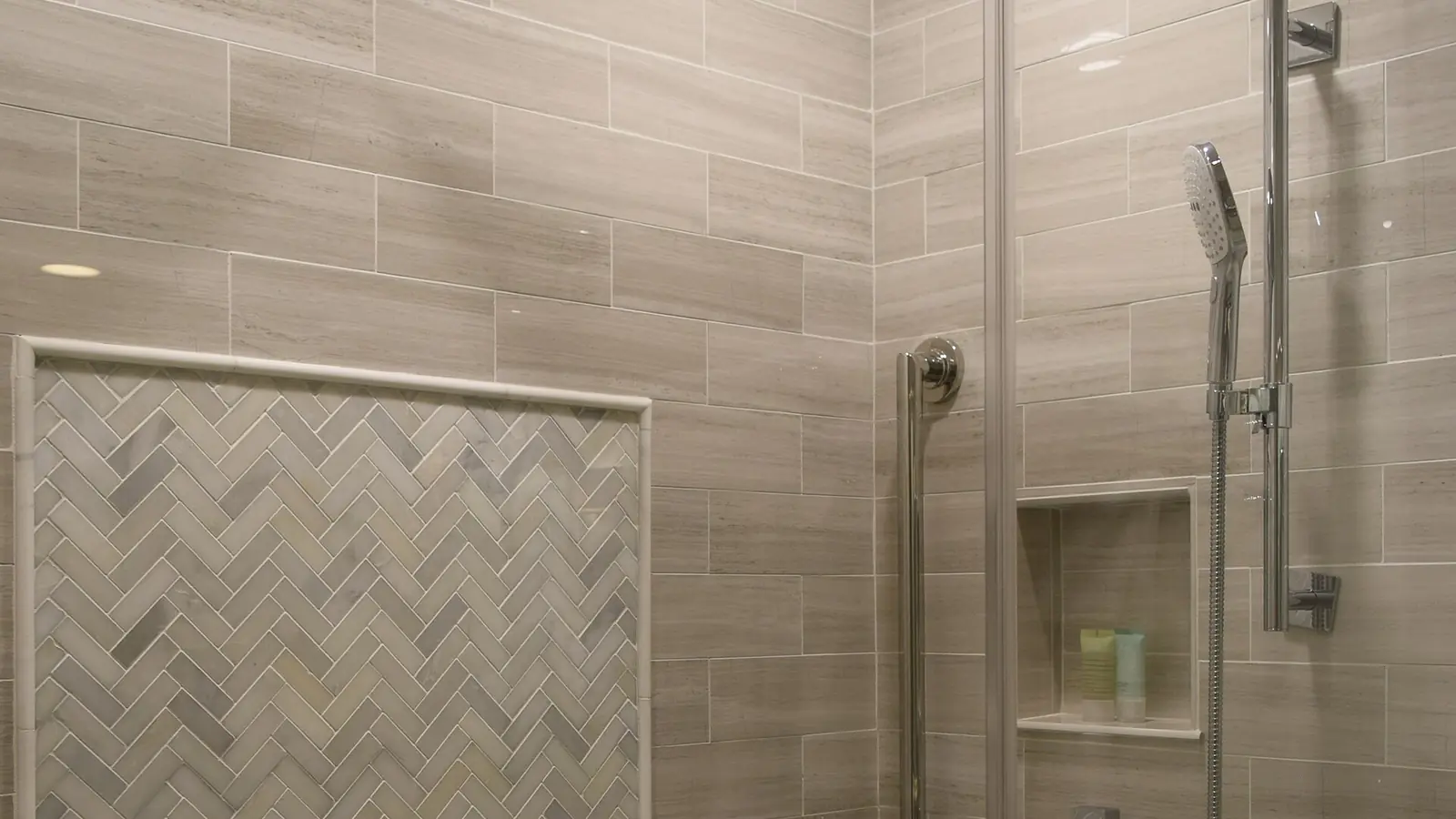 Walk-in shower with frameless glass, rain showerhead and herringbone tile